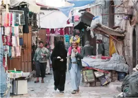  ??  ?? SANAA: Yemenis walk through a market in the old city of the capital yesterday. —AP