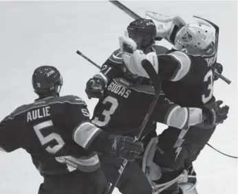  ?? RENE JOHNSTON/TORONTO STAR ?? Norfolk’s Keith Aulie and Radko Gudas celebrate with netminder Dustin Tokarski after teammate Mike Kostka’s bizarre — and illegal — goal in overtime lifted the Admirals to victory in Game 3 of the Calder Cup final.