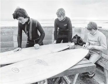  ?? PHOTO: ODT FILES ?? Fine weather and good surf attracted many high school students to St Clair Beach over the school holidays. Waxing up their boards in September 1980 are, from left, David Biss, Paul Hansen and John Crighton.