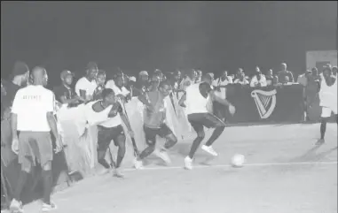  ??  ?? Okeene Fraser (centre) of Leopold Street, trying to maintain possession of the ball, as an Avocado Baller attempts a challenge during their matchup in the Guinness Cage Street-ball Championsh­ip on Wednesday night