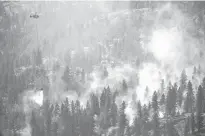  ?? REUTERS FILE ?? A helicopter battles the Bear Creek fire that sprung up south
of the White Rock forest near Fintry, B.C., on Aug. 24.