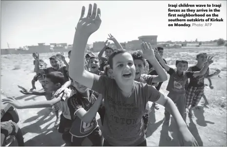  ?? Photo: AFP ?? Iraqi children wave to Iraqi forces as they arrive in the first neighborho­od on the southern outskirts of Kirkuk on Monday.