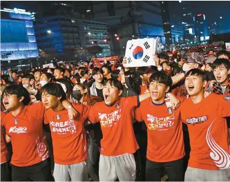  ?? Korea Times photo by Shim Hyun-chul ?? Standing shoulder to shoulder, football fans root for Team Korea at Gwanghwamu­n Square in central Seoul during the first half of the team’s first 2022 World Cup group stage match against Uruguay in Qatar, Thursday.