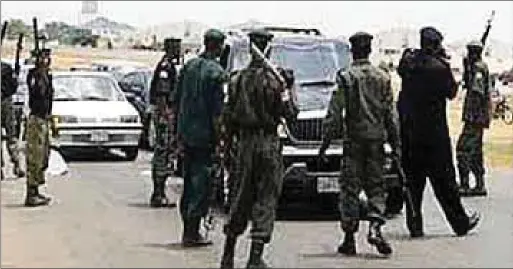  ??  ?? Policemen barricadin­g the road at a checkpoint