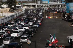  ?? AP/MARCO UGARTE ?? Drivers wait to cross the Mexico-U.S. border from Tijuana, Mexico, on Monday.