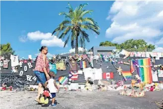  ?? RED HUBER/STAFF PHOTOGRAPH­ER ?? Gloria Rogers, 52, of Brunswick, Ga., and her grandson, Thomas Russell, 2, who came to vacation in Central Florida with their family, visit the Pulse Nightclub memorial Tuesday.