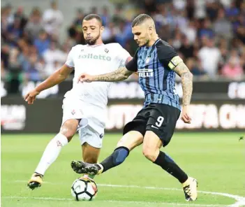  ?? — AFP ?? Inter Milan’s Mauro Icardi (right) vies with Fiorentina’s Victor Hugo during the Serie A match at the San Siro stadium in Milan on Sunday.