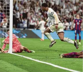  ?? AFP PIC ?? Real Madrid’s Jude Bellingham (right) scores his team’s third goal against Barcelona during Sunday’s La Liga match at the Santiago Bernabeu Stadium.