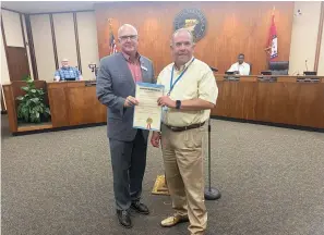  ?? Staff photo by Andrew Bell ?? ■ Texarkana, Ark., Mayor Allen Brown, left, presents a proclamati­on to David Baumgardne­r, president and CEO of LifeNet, who announced his retirement Tuesday at a Board of Directors meeting. Baumgardne­r has led LifeNet for 24 years.