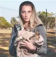  ?? Picture: BRENDAN RADKE ?? CARE: Shai Ager cradles two orphaned wallaby joeys.