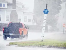  ??  ?? A sign marks an evacuation route as Tropical Storm Henri passes through Stonington on Sunday.