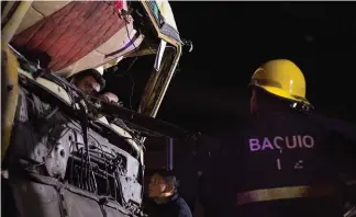  ?? Photo by Jean Nicole Cortes ?? MISHAP. A Bureau of Fire and Protection officer including other emergency medical teams rescues a driver stuck in his truck carrying aggregates. The truck lost breaks and plowed to a container van then pinned a taxi parked below the fly over near BGH Tuesday evening.