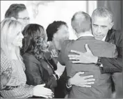  ?? Olivier Douliery
Abaca Press ?? PRESIDENT OBAMA hugs gun control supporter Mark Barden, father of a victim in the Newtown, Conn., shooting, before making his announceme­nt.