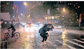  ?? FOTO: CRAIG RUTTLE/AP ?? Eine Fußgängeri­n überquert eine Straße in der Nähe des Columbus Circle in New York.
Die Ausläufer des Hurrikans „Ida“hatten die Metropole getroffen.