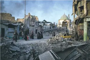  ?? FELIPE DANA/ASSOCIATED PRESS FILE PHOTO ?? Fleeing Iraqi civilians walk past the heavily damaged al-Nuri mosque July 4 in the Old City of Mosul, Iraq. A German girl, who ran away from home shortly after converting to Islam, has been found in Iraq, prosecutor­s said Saturday.