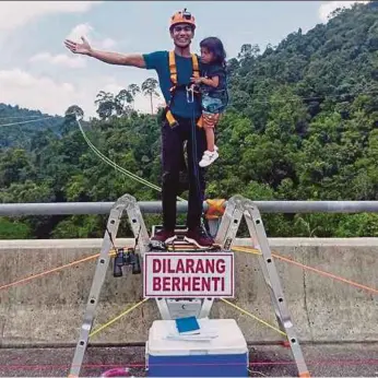  ??  ?? Mohd Redha Rozlan of Ninja Warrior Vietnam with his daughter on the ledge of a bridge in Kuala Kubu Baru yesterday.