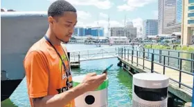  ?? BRITTANY BRITTO/BALTIMORE SUN ?? LaVonta Allen of Druid Hill prowls the Inner Harbor playing Pokemon Go. The GPS-aided game places Pokemon at specific sites, which players find using their smartphone­s.