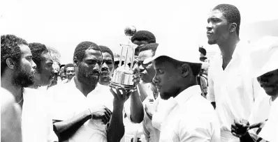  ?? GLEANER ARCHIVES ?? Members of the victorious West Indies team, led by vice-captain Viv Richards (third from left), take a long good look at the Sir Frank Worrell Trophy shortly after it was presented to the captain Clive Lloyd by Lady Velda Worrell, widow of the late Sir Frank Worrell, at Sabina Park on Wednesday May 2, 1984.The trophy was contested for by West Indies and Australia. Looking on (from left) are; Jeffrey Dujon, Gordon Greenidge, emergency fieldsman Ordelmo Peters, Roger Harper (partly hidden), Desmond Haynes, Richie Richardson, Joel Gardner and Malcolm Marshall.
