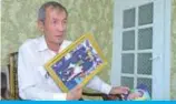  ?? — AFP ?? Uzbek journalist and former prisoner Dilmurod Said holds family photos of his wife and daughter, who died in a 2009 car crash, during an interview in Tashkent on July 26, 2019.