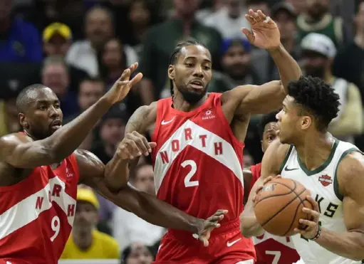  ?? The Associated Press ?? Kawhi Leonard, center, and the Raptors won three games in a row to push Giannis Antetokoun­mpo’s Bucks to the edge of eliminatio­n.