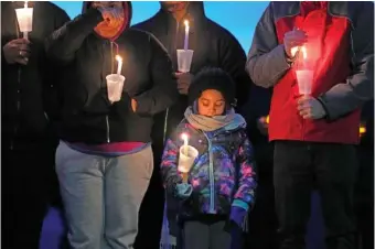  ?? AP PHOTO/CHARLIE NEIBERGALL ?? Local residents attend a candleligh­t vigil Thursday following a shooting at Perry High School in Perry, Iowa.