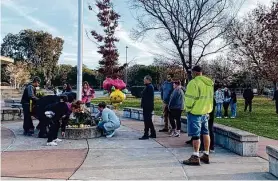  ?? Julie Johnson/The Chronicle ?? Parents bring flowers to Montgomery High School on Wednesday after a student was fatally stabbed during a fight.