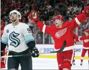  ?? DUANE BURLESON — THE ASSOCIATED PRESS ?? Detroit Red Wings right wing Lucas Raymond (23) celebrates his goal as Seattle Kraken center Marcus Johansson (90) reacts during the game Wednesday, in Detroit. The Red Wings defeated the Kraken 4-3 in a shootout.