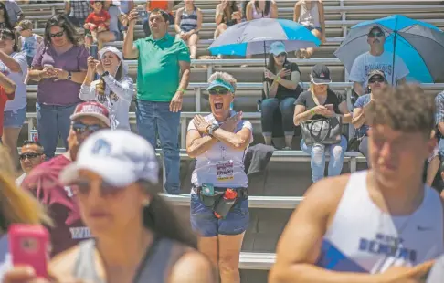  ?? PHOTOS BY JUAN ANTONIO LABRECHE/FOR THE NEW MEXICAN ?? Santa Fe Prep coach Tove Shere cheers her athletes at the podium Saturday during the Small-School Track and Field State Championsh­ips in Albuquerqu­e. After 21 years of coaching boys and girls teams at the school, she is stepping away.