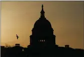  ?? CAROLYN KASTER — THE ASSOCIATED PRESS FILE ?? A bird flies near the U.S. Capitol dome in Washington at sunrise.