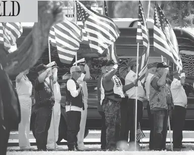  ?? RALPH FRESO / GETTY IMAGES ?? Military personnel and veterans salute as the funeral procession for Sen. John Mccain arrives Wednesday at the Arizona State Capitol in Phoenix. Mccain, a decorated war hero, died Saturday after a long battle with brain cancer.