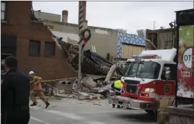  ??  ?? Firefighte­rs and rescue personnel work at the scene of building collapse in Sioux Falls, S.D., on Friday. A fire official says rescue workers are concerned about debris shifting as they try to free two people in the collapsed building. AP PHOTO/JAMES...