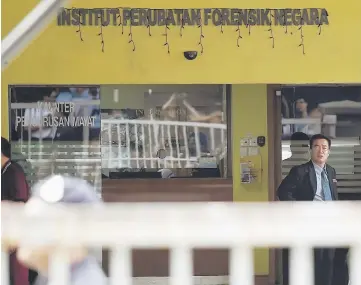  ??  ?? An unidentifi­ed North Korean embassy official (right) stands outside the Forensic wing at the Hospital Kuala Lumpur in Kuala Lumpur, where the body of a North Korean man suspected to be Kim Jong-Nam, half-brother of North Korean leader Kim Jong-Un, is...