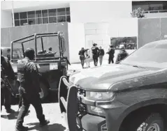  ??  ?? La fémina y otro joven son escoltados por policías y militares al llegar al edificio de la FGR.