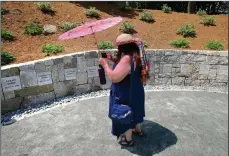  ?? (File Photo/AP/Stephan Savoia) ?? Karla Hailer, a fifth-grade teacher from Scituate, Mass., shoots a video July 19, 2017, where a memorial stands at the site in Salem, Mass., where five women, including Elizabeth Johnson Jr., were hanged as witches more than 325 years earlier. In 2021, Massachuse­tts lawmakers formally exonerated Johnson 329 years after she was convicted of witchcraft in 1693 and sentenced to death at the height of the Salem Witch Trials. Johnson is believed to be the last accused Salem witch to have her conviction set aside by legislator­s.