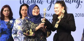  ??  ?? Rohani presents the Strategic Partner in Training Women in Digital Technology and Entreprene­urship award to Limkokwing University and Leadership in Capacity Building Towards Women Empowermen­t award to Lim Kok Wing University president Tan Sri Dr Prof Emeritus Dr Lim Kok Wing at the Internatio­nal Women’s Day celebratio­ns. Limkokwing University vice-president Datuk Tiffanee Marie Lim (right) receives the awards on Dr Lim’s behalf. — Bernama photo