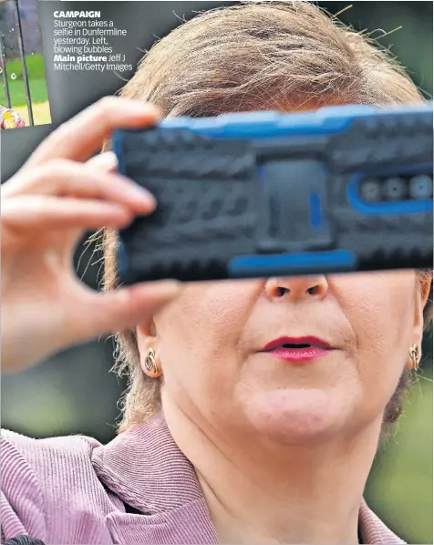  ?? ?? CAMPAIGN Sturgeon takes a selfie in Dunfermlin­e yesterday. Left, blowing bubbles Main picture Jeff J Mitchell/Getty Images