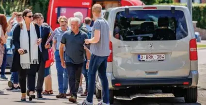  ?? FOTO DIRK VERTOMMEN ?? Echtgenoot Michel (tweede van rechts) en enkele andere familieled­en konden de reconstruc­tie volgen vanuit een busje.