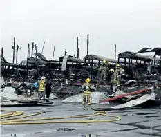  ?? MICHAEL RUBINKAM/ THE ASSOCIATED PRESS ?? Firefighte­rs clear wreckage from a school bus depot in South Whitehall, Pa., that was destroyed by fire on Friday.