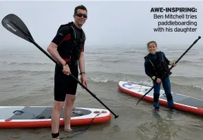  ??  ?? AWE-INSPIRING: Ben Mitchell tries paddleboar­ding with his daughter