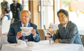  ?? PHOTO BY DOUG MILLS/THE NEW YORK TIMES ?? President Donald Trump and Prime Minister Shinzo Abe of Japan sign golf hats Sunday before heading out to golf at Kasumigase­ki Country Club in Kawagoe, Japan.