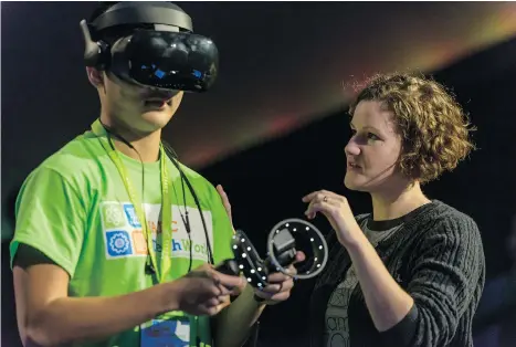  ??  ?? A student tries out a virtual reality headset during the morning plenary.