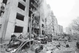  ?? SERGEY DOLZHENKO EPA-EFE via UPI ?? Rescuers work at the site of a missile strike in Kyiv, Ukraine, on Tuesday.