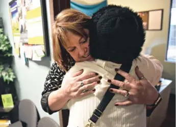  ??  ?? Rocky Mountain CARES executive director Shannon Southall hugs a patient at the clinic Friday. The advocacy group works with HIV/AIDS patients. Andy Cross, The Denver Post