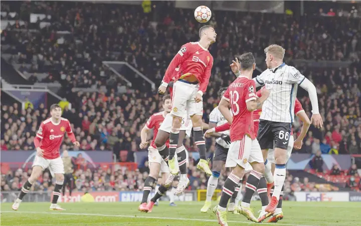  ?? — AFP ?? Manchester United’s Portuguese striker Cristiano Ronaldo jumps to head the ball during the Uefa Champions league Group F match against Atalanta at Old Trafford stadium in Manchester. Manchester United won the match 3-2.