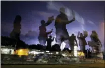  ?? JEFF ROBERSON — THE ASSOCIATED PRESS FILE ?? In this file photo, protesters march in the street as lightning flashes in the distance in Ferguson, Mo., following the shooting of Michael Brown, an unarmed black 18-year old, in the St. Louis suburb on Aug. 9, 2014. Last week, an off-duty officer in...