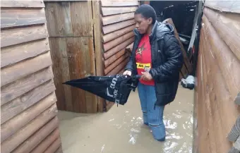  ??  ?? Phumza Mzala outside her flooded house.