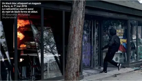  ??  ?? Un black bloc attaquant un magasin à Paris, le 1er mai 2018.La radicalité se nourrit aussi du rejet de toute forme de débat.(© Alexandros Michailidi­s/ Shuttersto­ck)