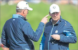  ??  ?? Europe skipper Thomas Bjorn speaks to assistant Robert Karlsson