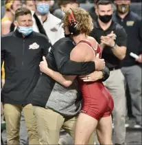  ?? KYLE FRANKO — TRENTONIAN PHOTO ?? Rider’s McKenzie Bell, right, hugs coach John Hangey, left, after Bell defeated Missouri’s Allan Ball, 8-6, in a 141-pound semifinal bout at the MAC Championsh­ips on Friday in Trenton.