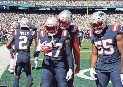  ?? Bill Kostroun / Associated Press ?? The Patriots’ J.C. Jackson (27) celebrates his intercepti­on during the first half against the Jets on Sunday in East Rutherford, N.J.